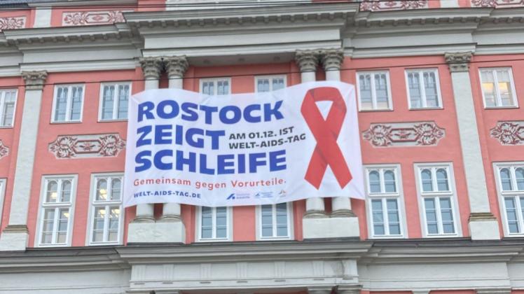 Rostock zeigt Schleife: Seit Donnerstag hängt das Banner zum Welt-Aids-Tag am Rostocker Rathaus.