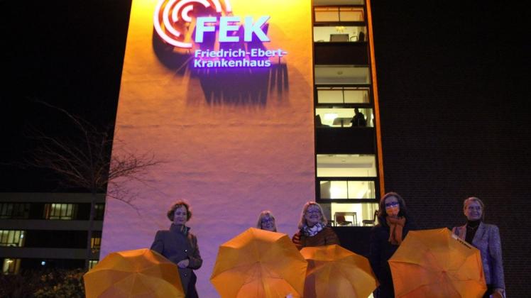 Dr. Svenja Thiele (von links), Jutta Meyer, Petra Strahl und Babett Schwede-Oldehus freuen sich mit der FEK-Geschäftsführerin Kerstin Ganskopf über das orangefarbene Leuchtfeuer am FEK-Gebäude.
