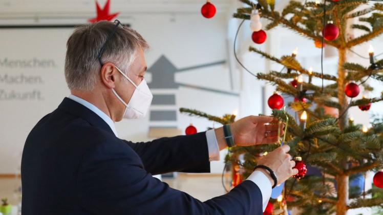 Wemag-Vorstand Thomas Murche bringt die Karten mit den Wünschen der Kinder am Weihnachtsbaum an.