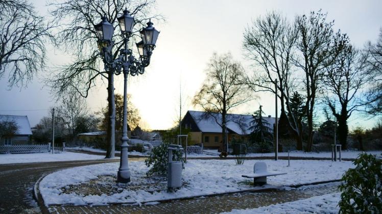 Eine feiner Schneedecke liegt auch in Nesow auf Wiesen, Gehwegen, Laternen und Bänken.