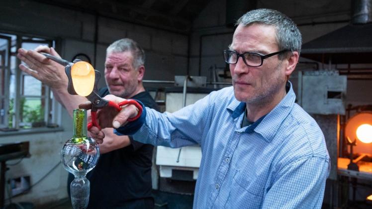 Norbert Kaufmann sowie Riccardo Jegodtka setzen auf 1200 Grad Celsius erhitztes Glas zu  einem Trinkgefäß zusammen.
