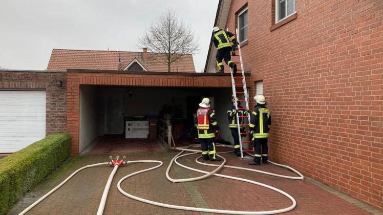 Von Außen kontrollieren Einsatzkräfte der Feuerwehr das Dach der Garage in Spelle-Varenrode und den Hobbyraum nach Brandschäden.