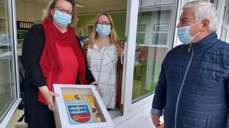 Ein erster Gruß für die Senioren in der Zarrentiner Schaalsee-Residenz: Bürgermeister Klaus Draeger überbringt eine Torte im Namen der Stadt. Die Mitarbeiter nahmen sie am Fenster in Empfang.