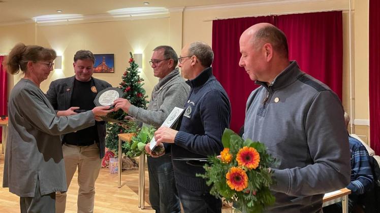 Birgit Menshen vom Spielmannszug und SV-Vereinsvorsitzender Ingolf Ehrhardt beglückwünschen die langjährigen Mitglieder Horst Loga, Frank Peiser und Harald Pinnau.