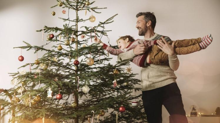 Gemeinsam den Baum zu schmücken, ist in vielen Familien Tradition. Das früh zu tun, kann glücklich machen.
