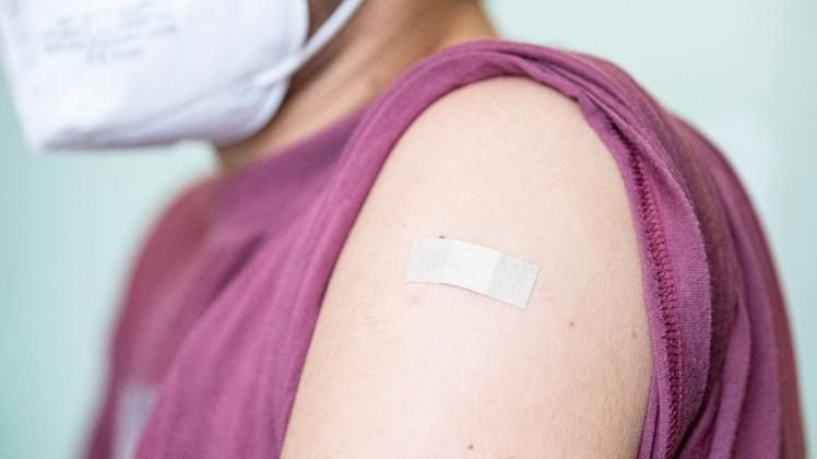 Auf dem Arm eines Mannes klebt ein Pflaster, nachdem er mit einem Corona-Impfstoff geimpft wurde.