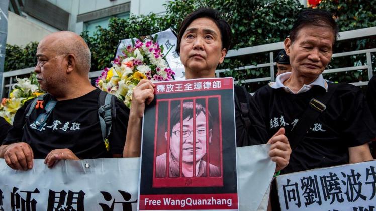 Die ehemalige Anwältin Emily Lau hält bei einem Protest im vergangenen Jahr ein Bild von Wang Quanzhang. Foto: afp/Isaac Lawrence
