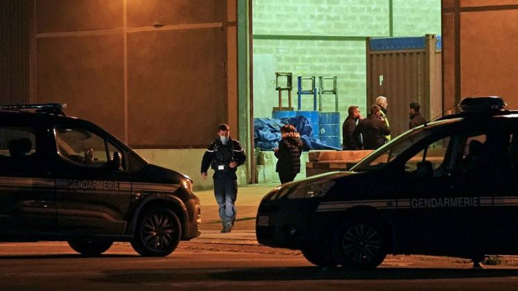 Fahrzeuge der Gendarmerie stehen vor einem Lagerhaus im Hafen von Calais.