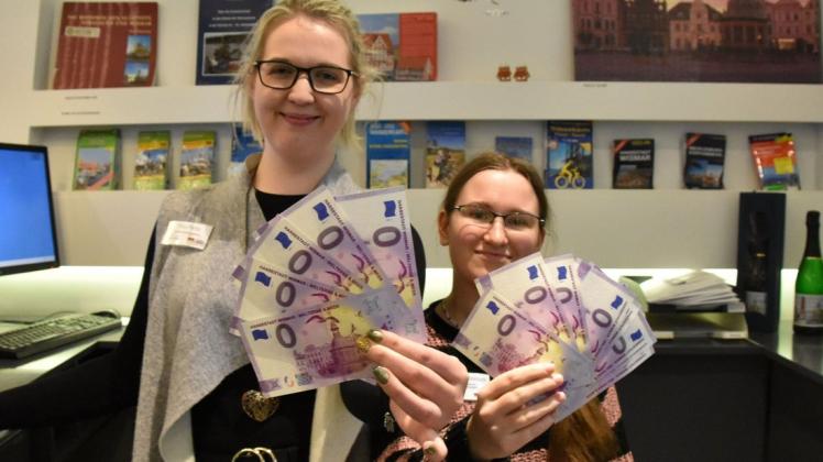Haben mehr als die Hälfte der 3000 Null-Euro-Scheine schon verkauft: Laura Parbs und Nicole Schönbach von der Tourist-Info in Wismar.