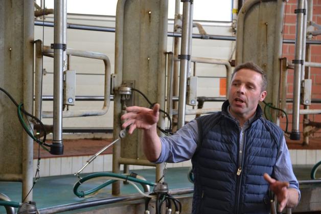 Landwirt Henning Kruse erläutert auf seinem Hof, wie das Melkkarussell funktioniert, das Platz für 28 Kühe bietet.