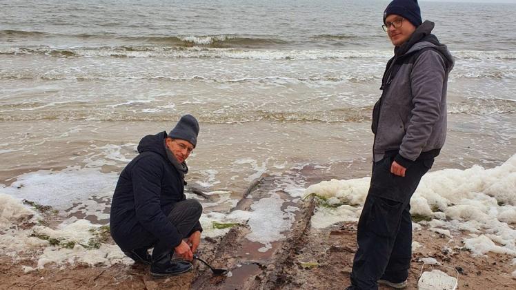 Bürgermeister Rene Roloff (links) mit seinem Fund am Darßer Weststrand