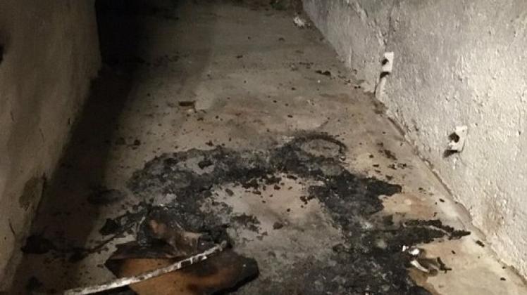 Reste des vermutlich in Brand gesteckten Kinderwagens im Keller des Wohnblocks