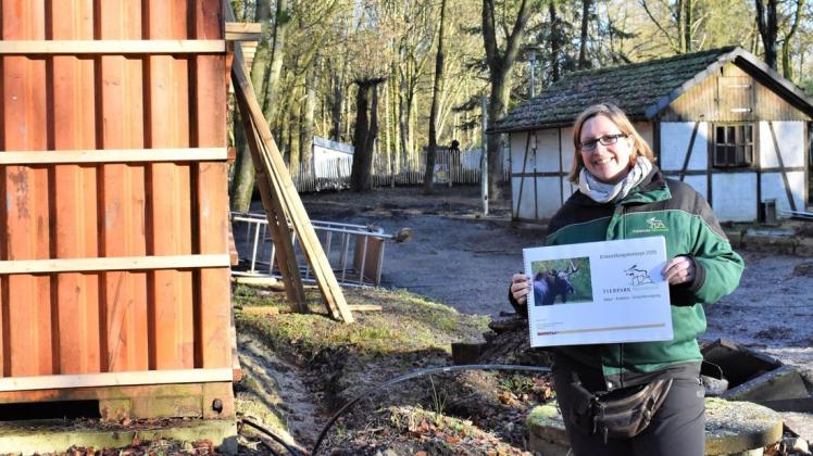 Tierpark-Chefin Verena Kaspari hält den Entwicklungsplan bis 2035 in den Händen. Er umfasst zahlreiche Projekte. Eines davon ist die Fertigstellung des Kleintierhofes (im Hintergrund), die für Ostern geplant ist.