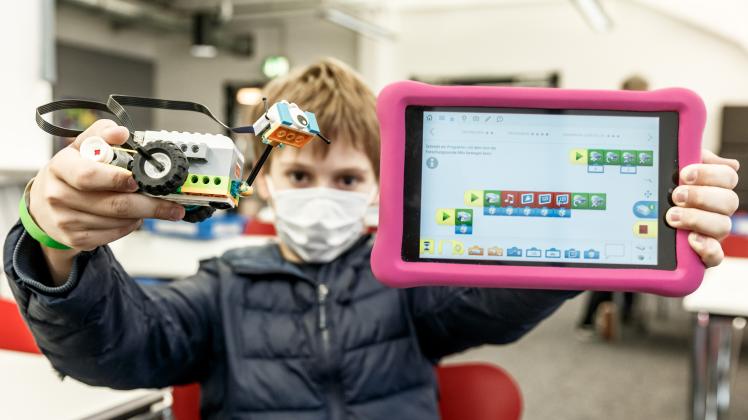 Moritz zeigt sein aus WeDo-Legobausteinen gebautes Fahrzeug. Mit dem Tablet-Computer hat er ihn programmiert.
