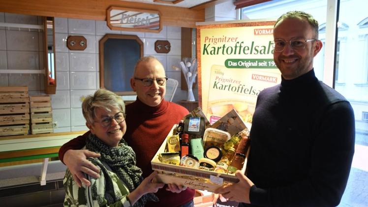 Roy Hartung überreicht den bisherigen Ladenbesitzern Ute und Harald Prüter eine Kiste mit regionalen Produkten.