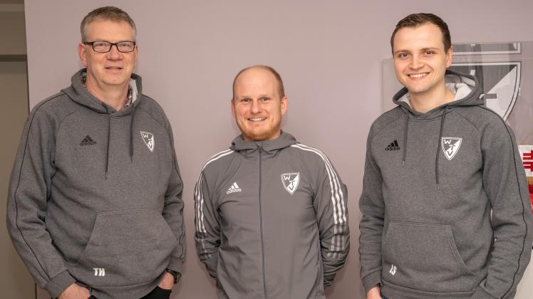 Abteilungsvorsitzender Thomas Hackmann und Herrenwart Leon Stieve (rechts) freuen sich, dass Mathias Lührmann (Mitte) Trainer beim Fußball-Kreisligisten TV Wellingholzhausen bleibt. 