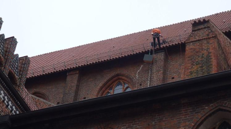 Die Nistkästen für die Turmfalken werden am Kirchenschiff installiert.