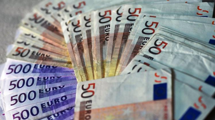 Viele Euro-Banknoten liegen ausgebreitet auf einem Tisch.