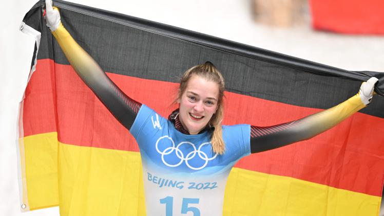 Germany's Hannah Neise celebrates with the German flag after winning the gold medal in the final run of the women's skeleton event at the Yanqing National Sliding Centre during the Beijing 2022 Winter Olympic Games in Yanqing on February 12, 2022. (Photo by Daniel MIHAILESCU / AFP)