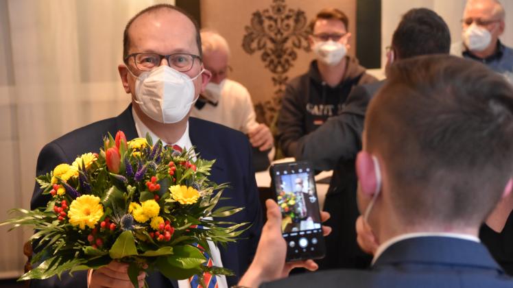 Sofort im Visier der Smartphones von Parteikollegen: CDU-Kandidat Jürgen Waßer mit Maske und Blumen.