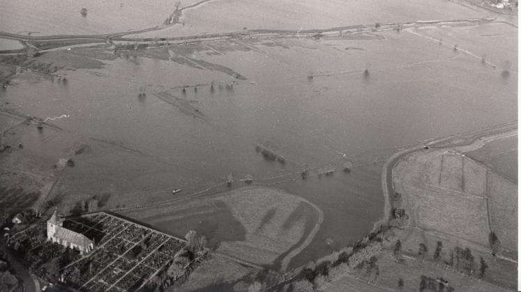Wassermassen, so weit das Auge reicht: So präsentierte sich das Gebiet zwischen dem Dorf Hasbergen und der Ochtum nach der Sturmflut vom 16./17. Februar 1962. Links unten ist die St.-Laurentius-Kirche samt Friedhof zu erkennen.