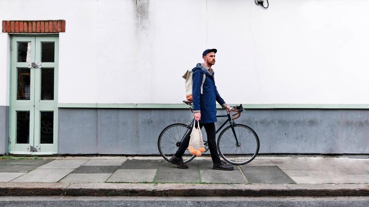 Man with bag of oranges wheeling with bicycle on footpath model released Symbolfoto ASGF00235
