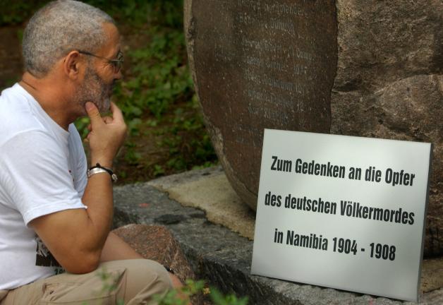 100 Jahre nach dem Genozid: Israel Kaunatjike, Angehöriger des Herero-Volkes, betrachtet  auf dem Garnisonfriedhof in Berlin eine Gedenktafel für die „Opfer des deutschen Völkermordes in Namibia von 1904 bis 1908“.