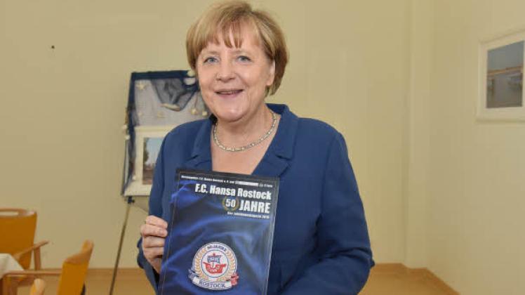 Bundeskanzlerin Angela Merkel mit dem Hansa-Jubiläumsjournal: Erinnerungen aus 50 Jahren Vereinsgeschichte.