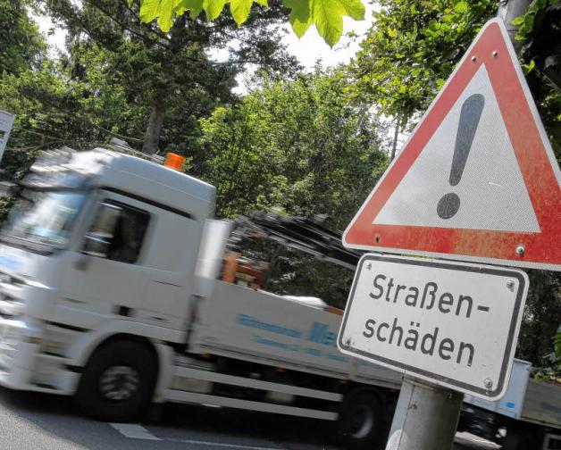 Achtung, Schlaglöcher: Schilder warnen im Rostocker Tannenweg vor Straßenschäden. Jetzt startet die Sanierung.