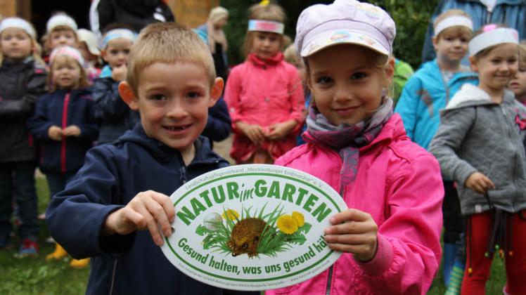 Stolz zeigen die beiden Vorschulkinder Frode und Laura die Plakette der Aktion „Natur im Garten“.  Fotos: Anne Schwartz 