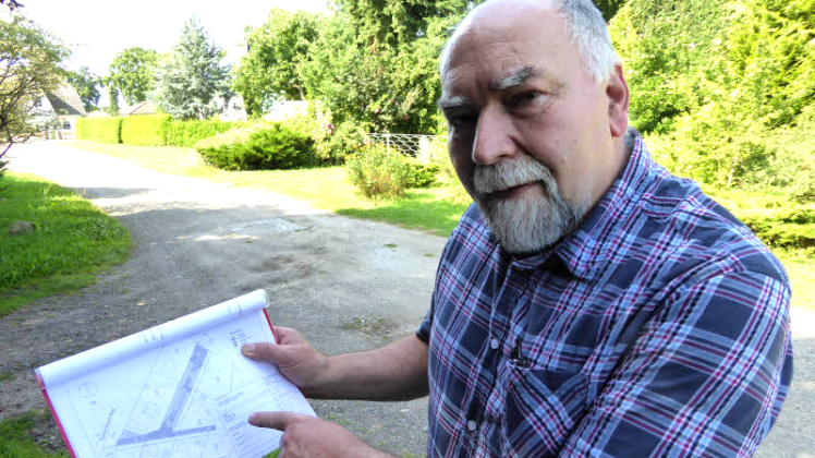 Gemeindevertreter Georg Wendt mit einem Kartenauszug aus der Eichenallee in Pritzier: „Wir brauchen hier keinen Ausbau.“
