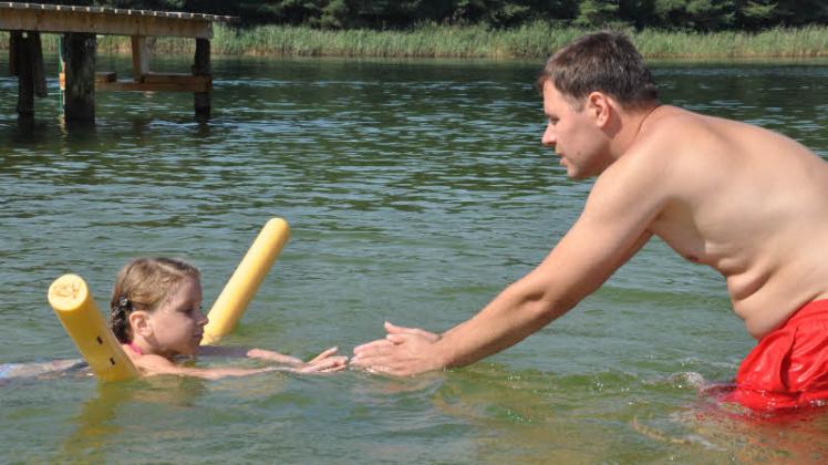 Rettungsschwimmer Nico Kobus-Prehn erklärt die Armzüge. Nach einer Woche Schwimmunterricht fühlt Ronja sich sicherer im Wasser.