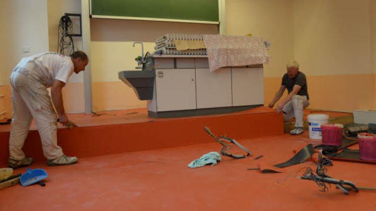 Mitarbeiter der Malerfirma Thiede verlegen in der Reuterschule Fußböden. 
