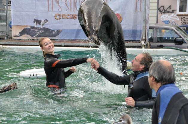 Achtung, er rauscht heran: Julia und Tierlehrer Roland Duss ließen die gelehrigen Seelöwen über ihre verbundenen Arme springen. 