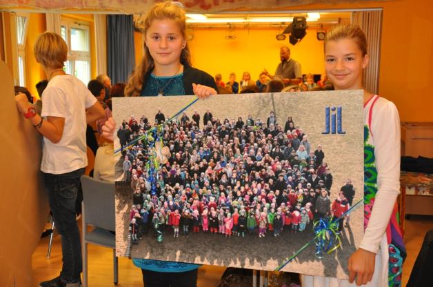 Mia Bernitt und Frieda Fichtner übergaben zum zehnten Schuljubiläum ein Foto, dass die gesamte Schülerschaft der Kinderkunstakademie Am Wasserturm zeigt.