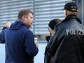 Vor der verschlossenen Geschäftsstelle des Fußball-Drittligisten FC Hansa Rostock spricht Vorstandsvorsitzender Michael Dahlmann (l) Polizisten an. 