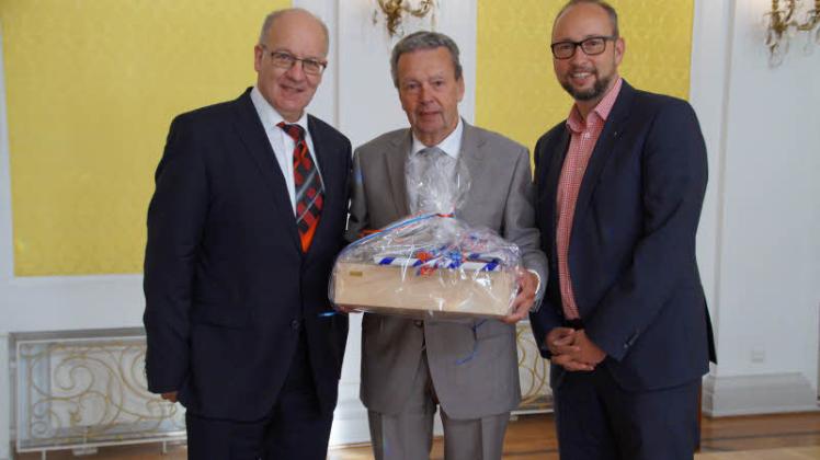 Zum Jubiläum der Stadtführer gratulieren OB Roland Methling (l.) und Tourismus-Chef Matthias Fromm (r.) Klaus Armbröster.