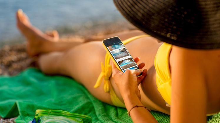 Viele Deutsche rufen auch im Urlaub dienstliche Mails über ihr Smartphone ab. 