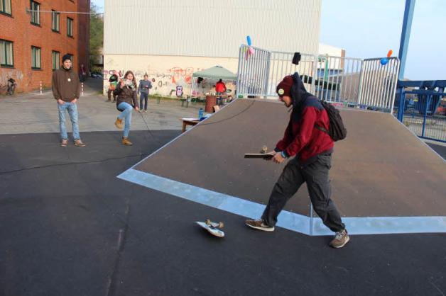 Max Schenk tauft den Park, indem er ein Skateboard zerbricht.