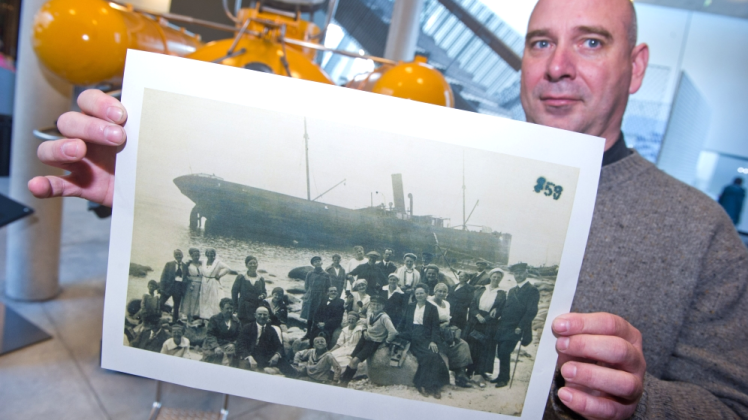 Unterwasserarchäologe Thomas Förster zeigt einen vergrößerten Ausdruck einer Postkarte des Schiffswrack „Svionia“.  
