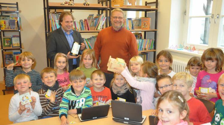 Unterricht mit Laptop: Tilmann Wesolowski (l.) von der Güstrower Bibliothek stellte den Erstklässlern der Kersting-Grundschule mit Schulleiter Ralph Grothe die neue Onleihe vor.  