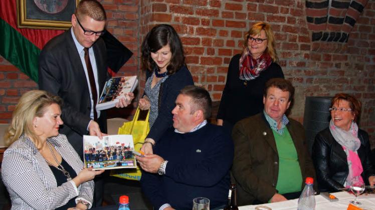 Bürgermeister Dirk Flörke (2.v.l.) und SVZ-Geschäftsstellenleiterin Nicole Boldt (Mitte) überreichen das Gruppenbild mit allen Akteuren des Martinimarktes 2015 zur Erinnerung. 