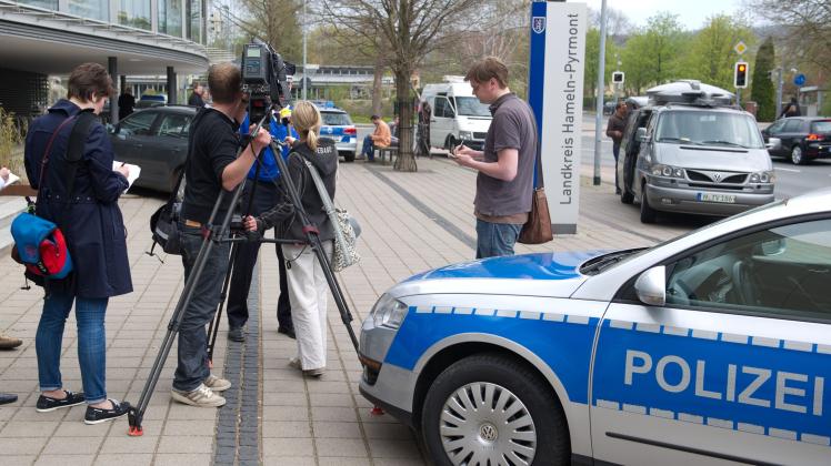 Polizisten und Journalisten vor dem Tatort in Hameln. 