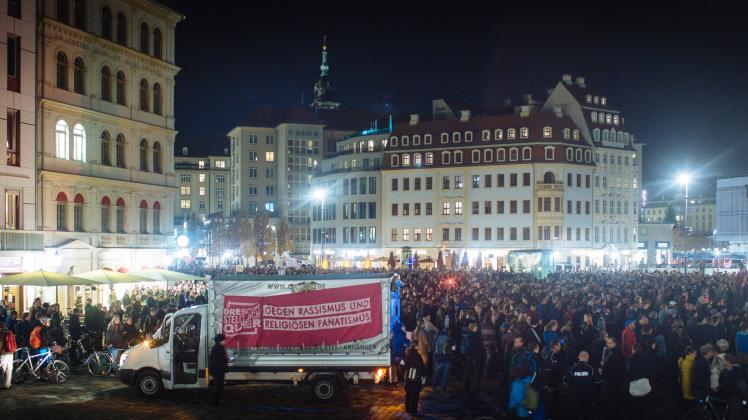Teilnehmer der Demonstration "Es reicht! Herz statt Hetze" stehen am Abend des 9. November in Dresden auf dem Neumarkt. 