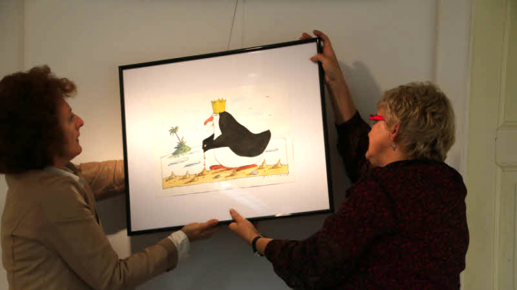 Annette Hübner und Sabine Prescher hängen eine Illustration für die heute beginnende Ausstellung im Krummen Haus auf. Fotos: Sabine Herforth