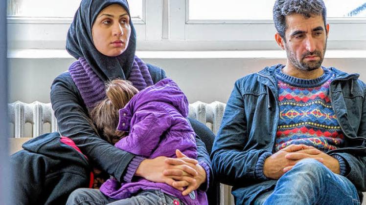 Eine Flüchtlingsfamilie wartet in einer neuen Bearbeitungsstrecke für Asyl-Anträge in Stern-Bucholz bei Schwerin