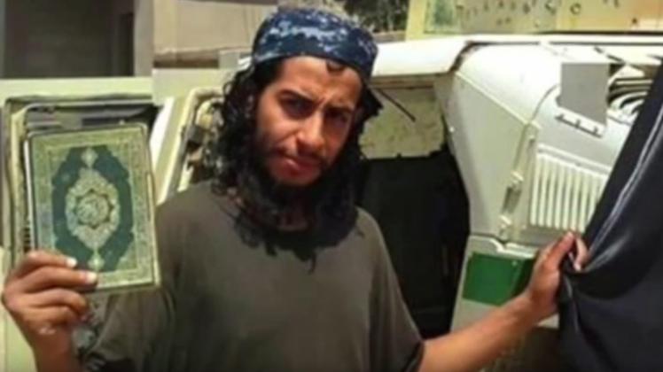 Abdelhamid Abaaoud hält den Koran und eine Flagge des IS  in die Kamera.  