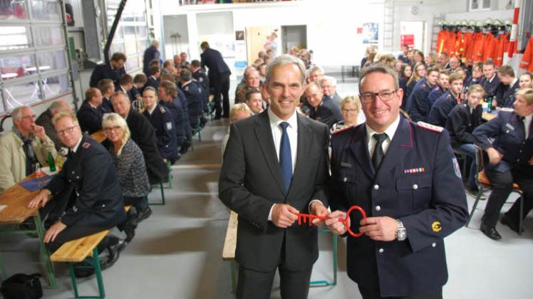 Schlüsselübergabe: Bürgermeister Heiko Traulsen (links) übergibt das neue Feuerwehrhaus Mehlby an den Ortswehrführer Dirk Schadewaldt. 
