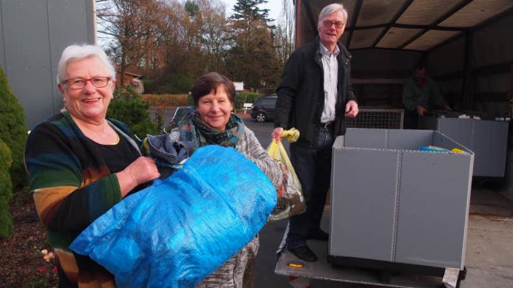 Die Helfer Anne Krey (v.l.), Elvira Flohr und Bernd Halbuer räumten am Montag die Spenden aus dem Lkw und sortierten sie für die Elmshorner Flüchtlinge.  