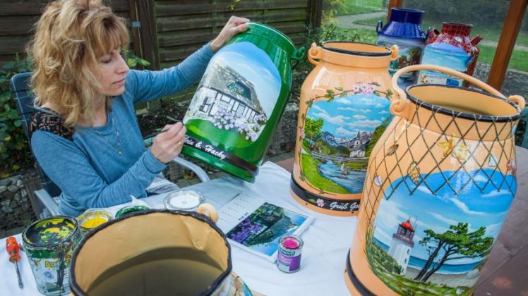 Hobbykünstlerin Kathrin Finck bemalt in ihrem Garten in Bernitt Milchkannen nach Kundenwünschen.  